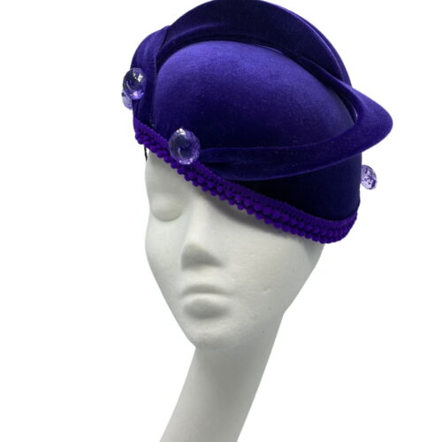 Cadbury purple velvet hat with purple swirl and finished with button detail to each end of swirl.